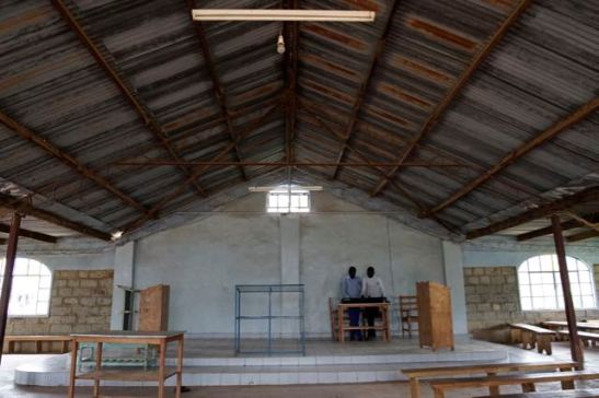 Inside the church building. This pastor has opened his church to Sudanese refugees. Two are playing a synthesizer here.
