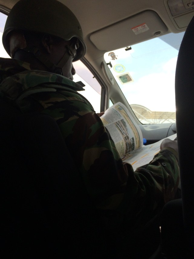 Machine gun toting army dude taking my seat and reading my paper during his shakedown of my driver Tony.